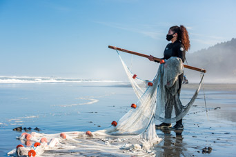 Student with a mask and a net at the beach