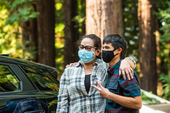 Student and parent with masks on hugging