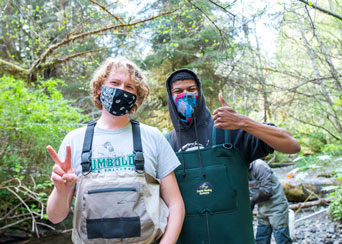 Two students with masks and fishing gear on