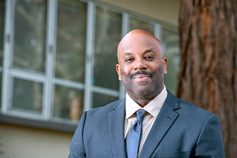 Photo of Morgan in front of a building and tree on the HSU campus