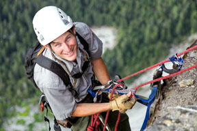 Greg Stock climbing a rock with harness