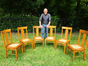 Christopher Matthews standing in front of a half circle of wooden chairs